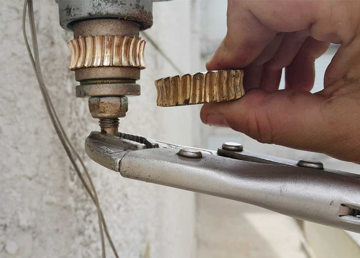 Comparação entre engrenagem de redução interna Peccinin desgastada no acionamento e engrenagem nova na mão do técnico — Itaquera SP